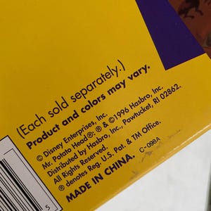 May include: Close-up of a yellow box with purple accents. Text includes "(Each sold separately.) Product and colors may vary." and copyright information for Disney Enterprises, Hasbro, and Mr. Potato Head. The box is marked "MADE IN CHINA."