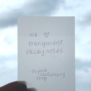 May include: A white sticky note with the text "We &hearts; transparent sticky notes" and "oxford stationery shop" written on it.