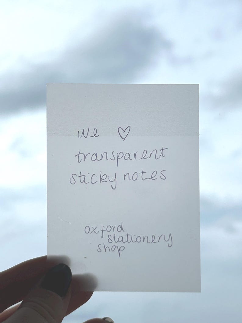 May include: A white sticky note with the text "We &hearts; transparent sticky notes" and "oxford stationery shop" written on it.
