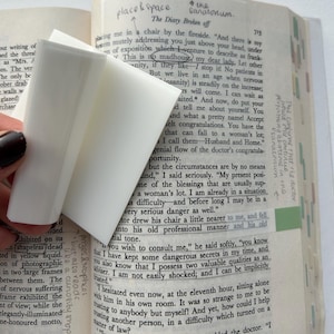 May include: A close-up of a book page with a white eraser on top of the text. The text is about a doctor and a patient. The text reads "This is no madhouse, my dear lady. Let other" and "But we live in an age when nervous insanity is steadily on the increase;"