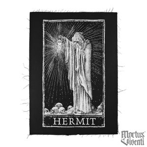 May include: Black and white embroidered patch with a hooded figure holding a lantern and the word "HERMIT" below. The figure is standing on a pile of skulls.