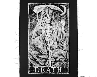 May include: Black and white embroidered patch featuring a skeletal figure in a hooded robe holding a scythe and a snake. The figure is sitting with its legs crossed. The text "DEATH" is printed below the figure.