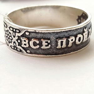 Può includere: Un anello d'argento con una fascia nera e l'iscrizione "ВСЕ ПРОЙДЁТ" in lettere bianche.