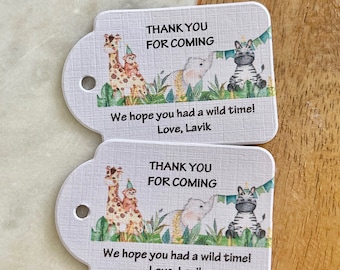 May include: Two white thank you tags with a jungle animal theme. The tags feature a giraffe, monkey, elephant, and zebra. The text on the tags reads "Thank you for coming. We hope you had a wild time! Love, Lavik."