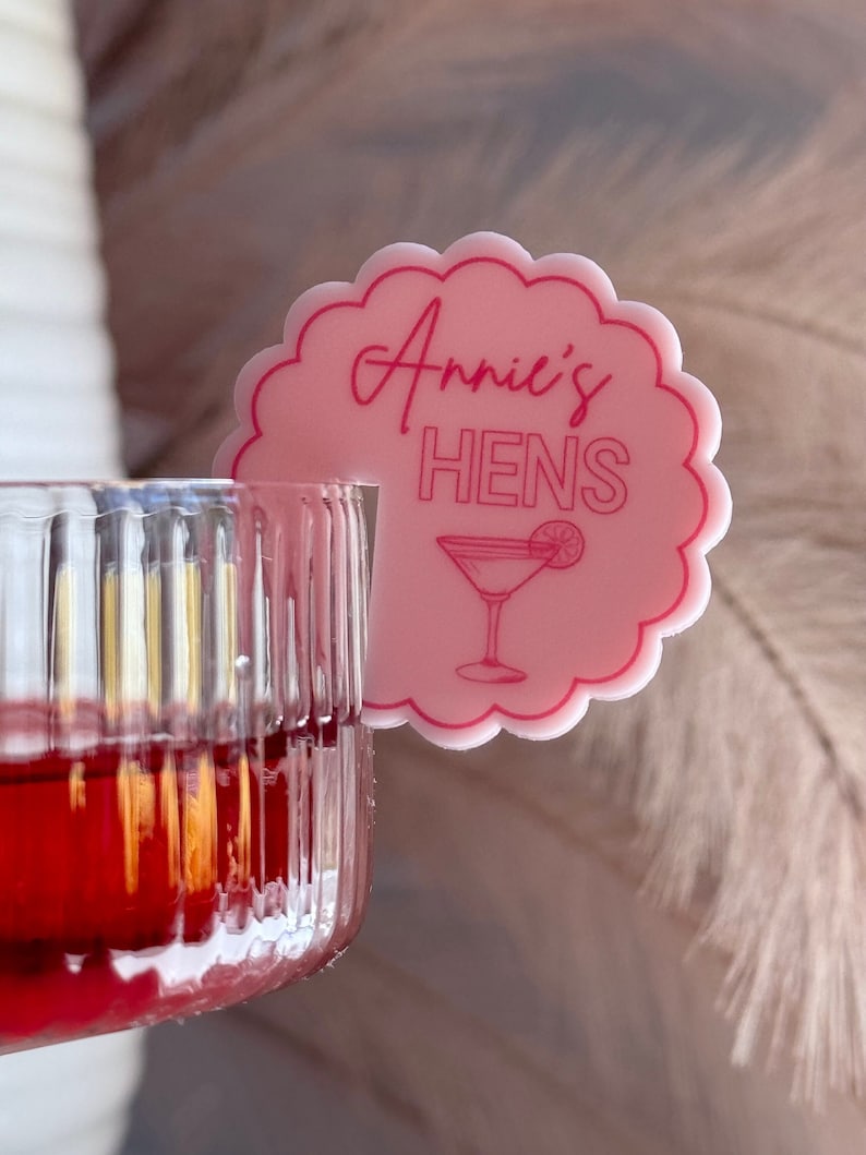 May include: Pink plastic drink marker with the text "Annie's Hens" and a cocktail glass illustration.
