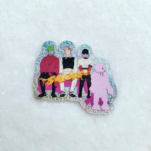 Könnte beinhalten: Ein Aufkleber mit vier Figuren in einer Band, auf einem rosa, glitzernden Hintergrund. Die Figuren tragen bunte Kleidung und haben ein gelbes, flammenartiges Design vor sich. Der Text "BAD LOVE" ist in gelben Buchstaben geschrieben.