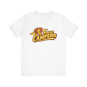 May include: White t-shirt featuring the "Pollo Campero" logo. The logo depicts a cartoon chicken wearing a cowboy hat and the words "Pollo Campero" in a yellow and brown font. The shirt is made of a soft material.
