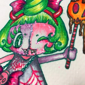 Op de afbeelding: Een cartoonillustratie van een personage met groen haar en een roze huid met een groene en gele spiraal op zijn hoofd. Het personage draagt een roze strik, een grijze jurk met een spinnenwebontwerp en een roze en zilveren ketting. Het personage houdt een snoepstok vast met een druipende oranje pompoen erop.
