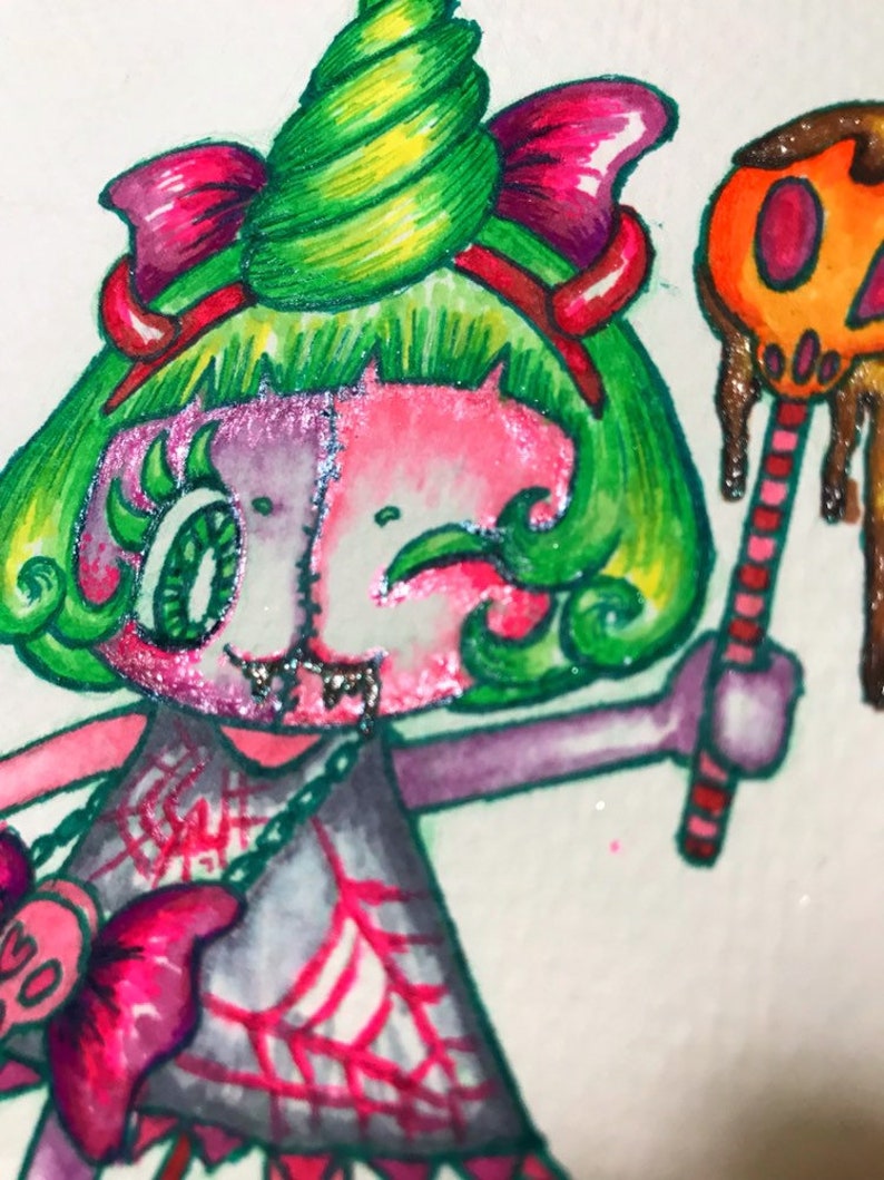 Op de afbeelding: Een cartoonillustratie van een personage met groen haar en een roze huid met een groene en gele spiraal op zijn hoofd. Het personage draagt een roze strik, een grijze jurk met een spinnenwebontwerp en een roze en zilveren ketting. Het personage houdt een snoepstok vast met een druipende oranje pompoen erop.