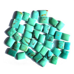 May include: A collection of turquoise cabochons, cut into square shapes, with a variety of shades of blue and green. The stones are arranged in a random pattern, with some overlapping.