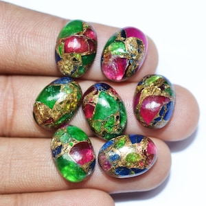 May include: Seven oval-shaped cabochon gemstones with a mix of green, red, blue, and gold colors. The stones are made of a variety of materials, including lapis lazuli, malachite, and ruby.