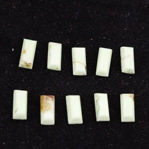 May include: Ten light green, rectangular, polished stones with a white background.