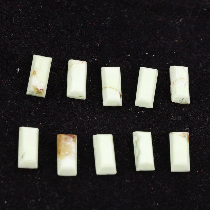 May include: Ten light green, rectangular, polished stones with a white background.