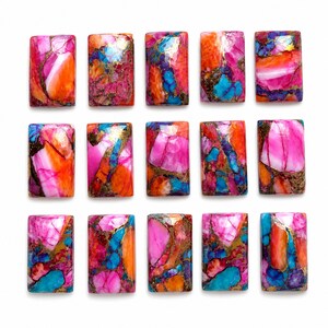 May include: Fifteen rectangular cabochons arranged in three rows of five. Each stone features a vibrant, multi-colored pattern of bright pink, orange, and turquoise segments separated by dark, metallic-looking veining throughout the polished surfaces.