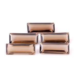 May include: Five rectangular, faceted gemstones in a smoky brown hue are displayed against a white backdrop. The gems have a polished, transparent appearance, with visible internal structures. The cut of the stones is a classic baguette shape.
