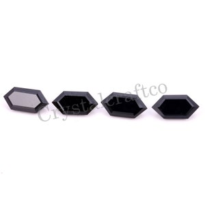 May include: Four black hexagonal shaped gemstones on a white background. The gemstones are faceted and have a high polish.