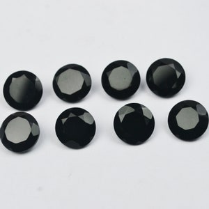 Peut inclure: Huit pierres précieuses rondes noires avec une taille facetée. Les pierres précieuses sont disposées en deux rangées de quatre.