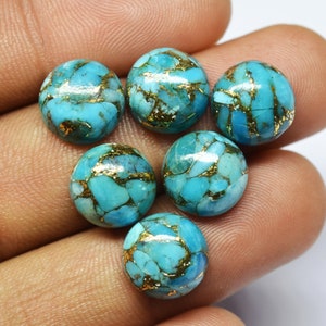 May include: Six round turquoise cabochons with gold flecks. The cabochons are approximately 10mm in diameter and have a smooth, polished surface.