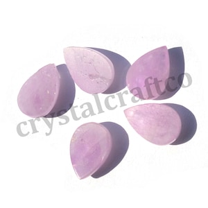 May include: Five pale lavender teardrop shaped gemstone cabochons. The cabochons are smooth and polished.