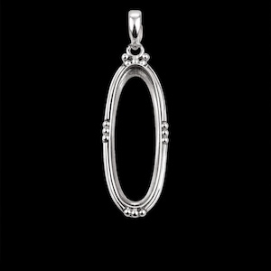 May include: A silver oval pendant with a decorative design. The pendant has a loop at the top for a chain and small beaded accents along the sides. The background is black.