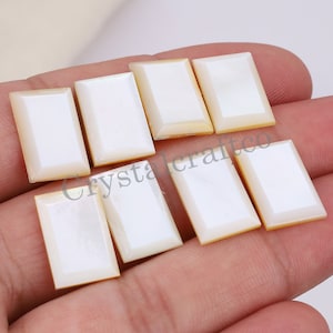 Puede incluir: Ocho cabujones rectangulares de madreperla blanca con un ligero brillo iridiscente. Los cabujones miden aproximadamente 2,5 cm de largo y 1,25 cm de ancho.