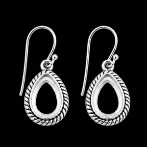 Könnte beinhalten: Ein Paar silberne Tropfenohrringe mit einem seilartigen Rand. Die Ohrringe haben ein schlichtes, elegantes Design mit einem Hakenverschluss. Der Hintergrund ist einfarbig schwarz und hebt den Schmuck hervor.