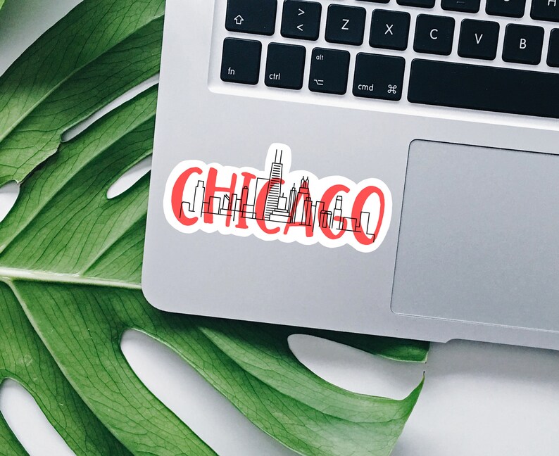 May include: A red and white sticker with a black outline of the Chicago skyline and the word "CHICAGO" in red lettering.