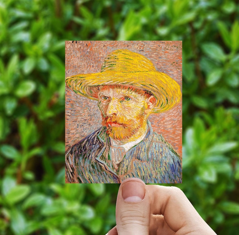 May include: A small rectangular print of Vincent van Gogh's self-portrait. The artwork features a man with a yellow straw hat, a red beard, and a blue jacket. The background is a mix of orange and brown tones, with green foliage in the background.