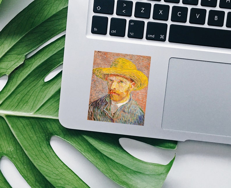 May include: A sticker featuring a portrait of Vincent van Gogh in a yellow hat. The artwork is a close-up of the artist's face, with visible brushstrokes and a textured appearance. The sticker is placed on a laptop.