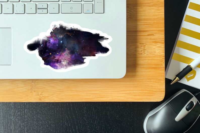 May include: A sticker featuring a watercolor-style galaxy with purple, blue, and pink hues. The galaxy is surrounded by a white border.