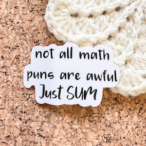 May include: White sticker with black text that reads "not all math puns are awful Just Sum".