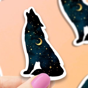 May include: A black wolf silhouette howling at the moon, with a starry night sky background. The moon and stars are gold.