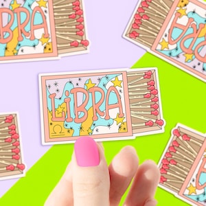 May include: A set of colorful stickers featuring the zodiac sign Libra. Each sticker is shaped like a matchbox and features a colorful design with stars and the word "LIBRA" written in a whimsical font.