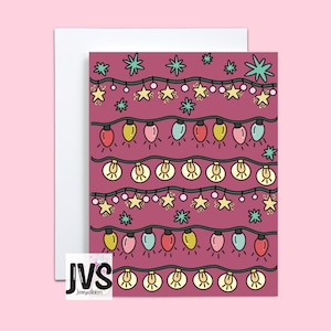 May include: A pink card with a repeating pattern of white and yellow lightbulbs, stars, and swirls. The lightbulbs are strung together in a line and the stars are scattered around them. The card has the text "JVS Jennyvalstickers" in the bottom left corner.