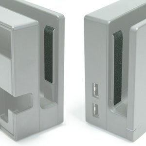 以下が含まれることがあります： 側面に黒いゴム製のインサートが付いた、灰色のニンテンドースイッチドッキングステーションが2つ。ドッキングステーションには、前面にUSBポートがあります。