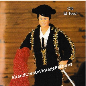 May include: A doll dressed as a matador, wearing a black suit with gold trim, a red cape, and a black hat. The doll is holding a sword. The text "Olé El Toro!" is in the upper right corner. The text "SitandCreateVintagePatterns" is in the image.