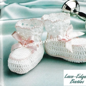 May include: A pair of white crocheted baby booties with pink lace edging and pink satin bows. The booties are on a light blue background. "Lace-Edged Booties" is written in black text below the booties.