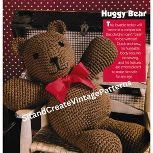 Può includere: Un orsacchiotto di peluche marrone all'uncinetto seduto su una sedia a dondolo di legno. L'orso ha un fiocco rosso intorno al collo e il testo "Huggy Bear" è scritto in rosso nella parte superiore dell'immagine. Il testo sotto l'orso dice "Questo adorabile orsacchiotto di peluche diventerà un compagno di cui i bambini non potranno "sopportare" di stare senza! Veloce e facile, il suo corpo abbracciabile non richiede cuciture, e le sue caratteristiche sono ricamate per renderlo sicuro per tutte le età."