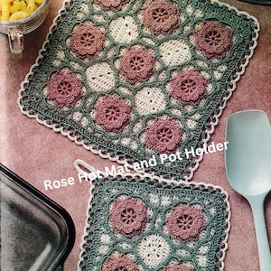 Könnte beinhalten: Zwei quadratische Topflappen aus Häkelarbeit mit Blumenmuster. Der größere Topflappen hat einen hellgrünen Rand und der kleinere einen weißen Rand. Beide Topflappen haben ein pinkfarbenes und weißes Blumenmuster. Der Text "Rose Hot Mat and Pot Holder" ist im Bild sichtbar.