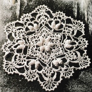 May include: A white crocheted snowflake doily with a delicate, intricate design. The doily is made with fine thread and has a lacy, openwork pattern.