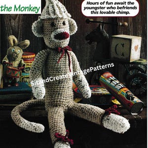 May include: A handmade crochet sock monkey doll with a white hat and red bow. The monkey has a white face and hands, and is wearing a red bow. The text "Socks the Monkey" is at the top left. The text "Hours of fun await the youngster who befriends this lovable chimp" is in a speech bubble.