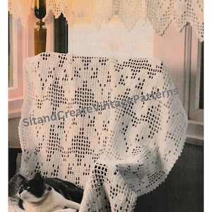 May include: A white crocheted blanket with a delicate pattern is draped over a chair. A black and white cat is sitting on the blanket. The blanket is made with a fine yarn and has a lacy look.