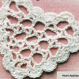 Pode incluir: Padrão de aplique de coração de crochê branco. O padrão é feito de pontos delicados e tem uma borda festonada.