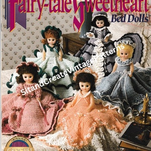 May include: A collection of vintage crochet bed doll patterns. The dolls are dressed in colorful, handmade crochet dresses. The image features the text "Fairy-tale Sweetheart Bed Dolls" and "Winning Crochet".