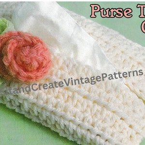 Puede incluir: Un cubre pañuelos de tejido blanco con un adorno de flores rosa y verde. La cubierta está etiquetada como "Purse Tissue Cover".