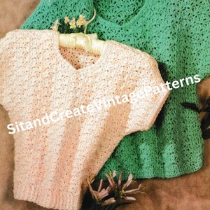 May include: Two crocheted tops, one in a light pink color and the other in a light green color. Both tops have short sleeves and a v-neck. The tops are on a brown surface with flowers.