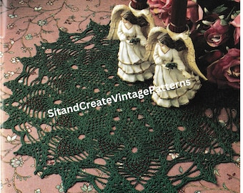 May include: Green crocheted doily with red beads, featuring a delicate lace pattern. The doily is displayed on a floral patterned surface with two decorative angel figurines.