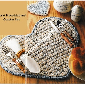 Puede incluir: Un juego de mantel individual y posavasos de ganchillo en forma de corazón, en azul y beige. El mantel individual está puesto con una servilleta blanca, un tenedor y un cuchillo. El posavasos está en el fondo.