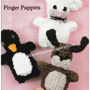 May include: Three crocheted finger puppets: a white bunny, a black and white penguin, and a brown and beige dog. The puppets are all wearing expressions and have small details like eyes, noses, and mouths. The puppets are on a pink background.