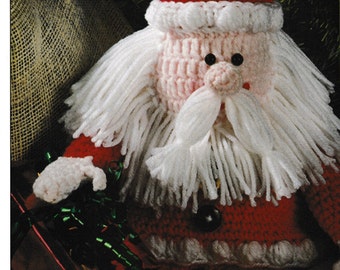 May include: Crocheted Santa Claus doll with a white beard and red hat. The doll is sitting on a wooden surface.